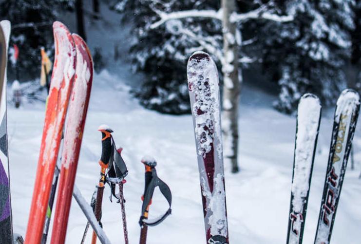 Skis stuck vertically in the snow at a mountain resort