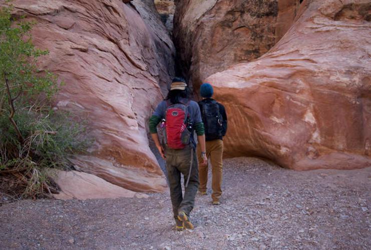 Hikers approaching slot canyon in Southern Utah