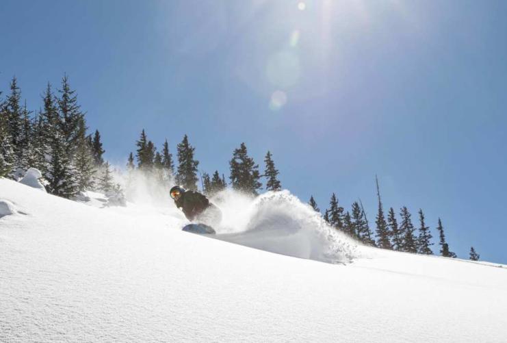 Snowboarder moving through deep powder