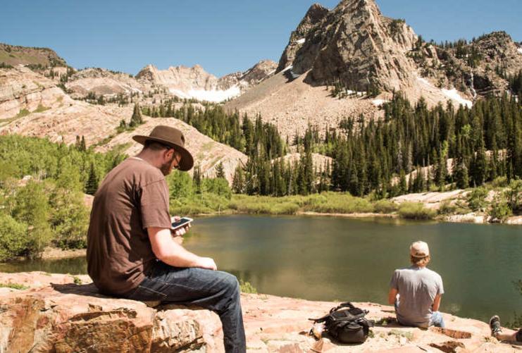 Hikers sitting by Lake Blanche and Sundial Peak