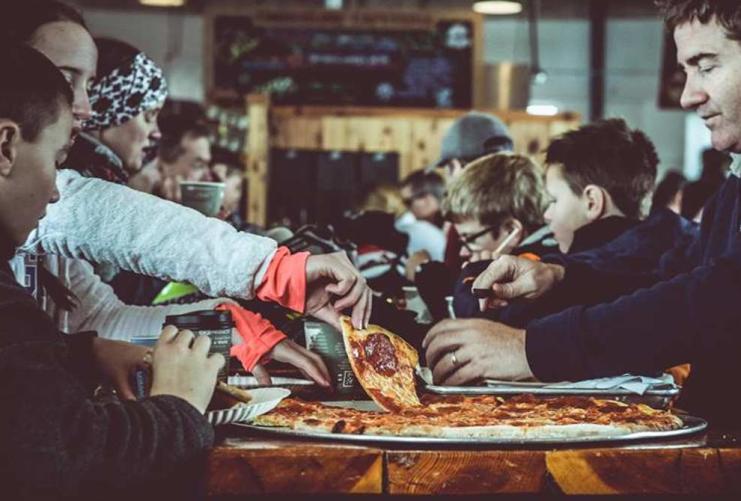 Family eating pizza together at ski resort