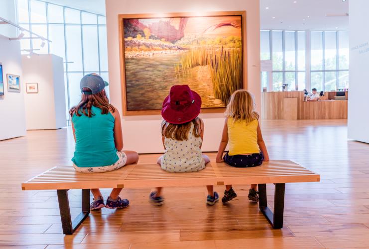 Three girls sit in front of an art piece at the Southern Utah Museum of Art in Cedar City, Utah