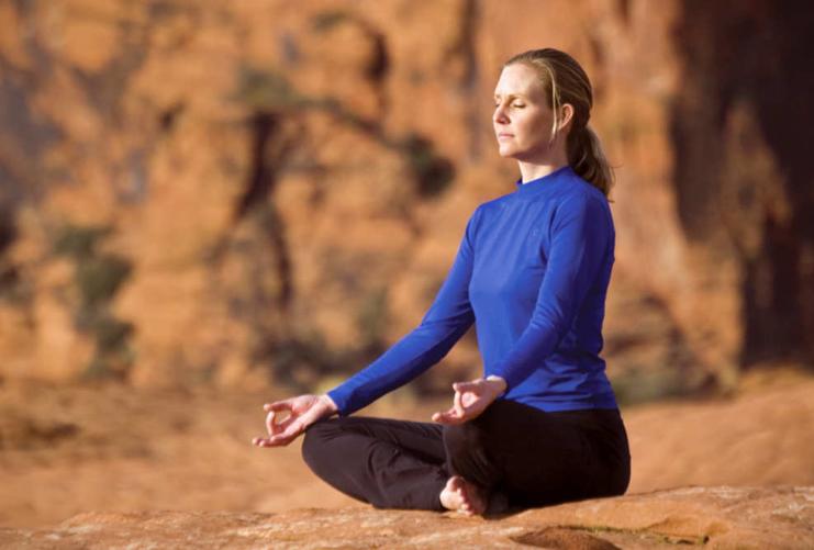 Woman sitting in a yoga pose in Snow Canyon State Park
