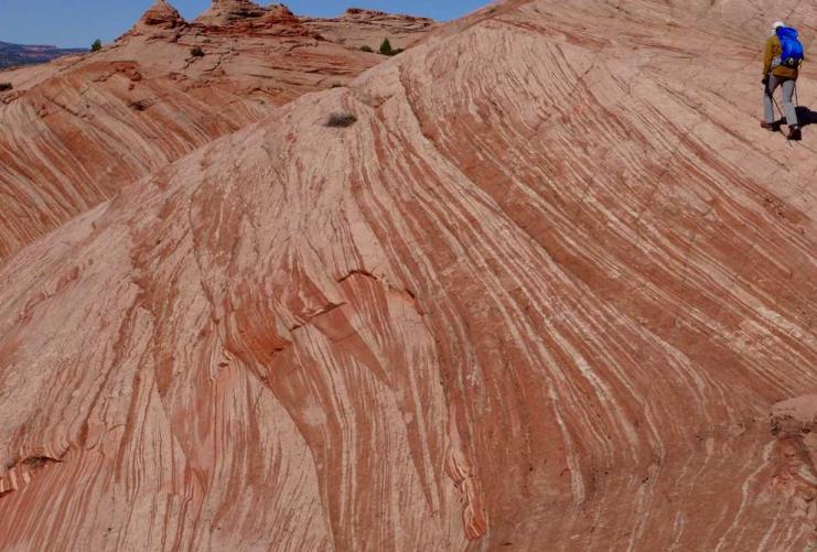 Striped sandstone and hiker at Boulder Utah