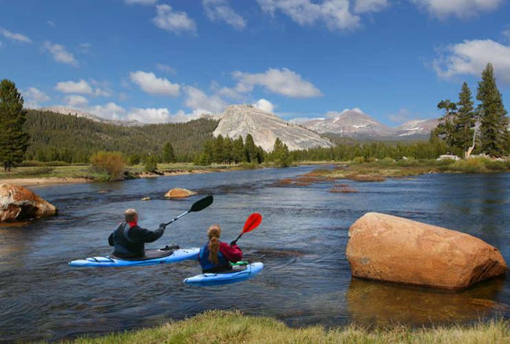 Kayakers paddling in mountain stream