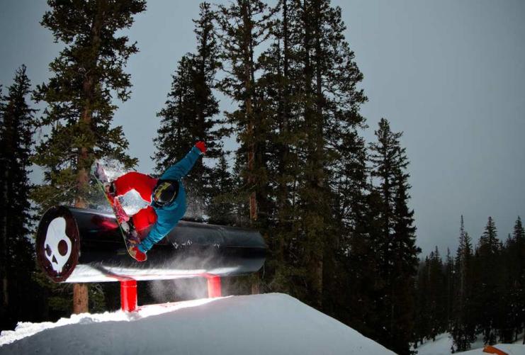 Snowboarder grinding on pipe at a Utah terrain park