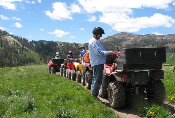 People riding four wheeler ATVs in the Utah mountains near Fillmore Utah.