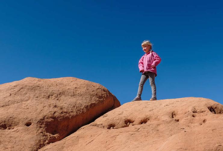 Photo of young girl standing on a boulder in Goblin Valley