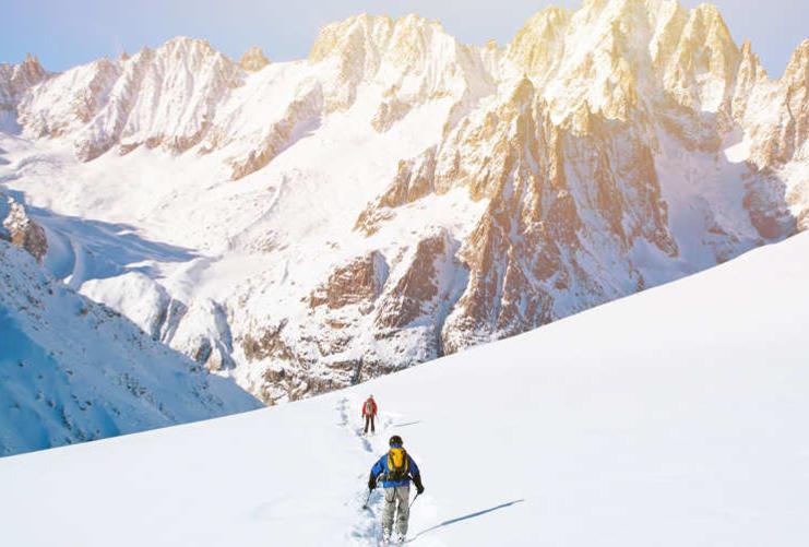 Group of skiers hiking in the high mountain peaks