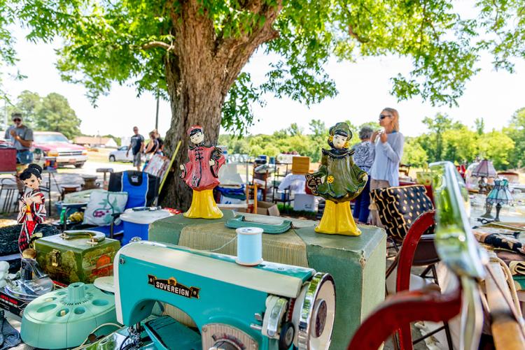 An old blue sewing machine and other items displayed at a yard sale