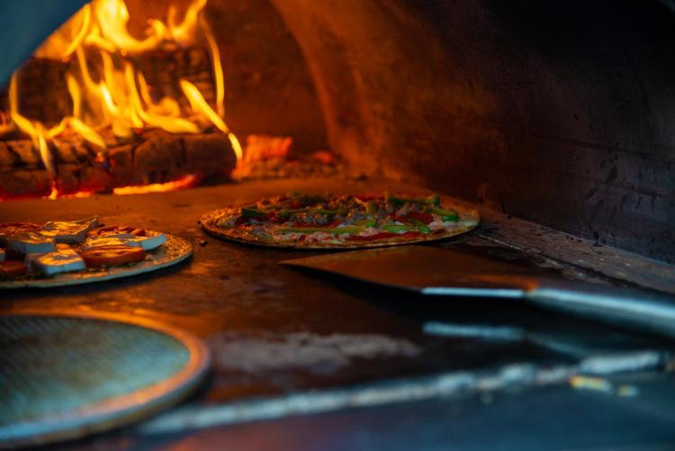 Fresh made pizzas cooking in a wood-burning oven