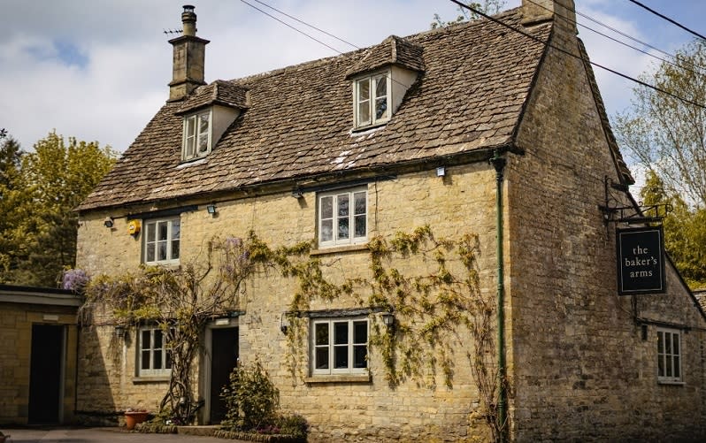 Wisteria climbs up the front of the honey-coloured Baker's Arms