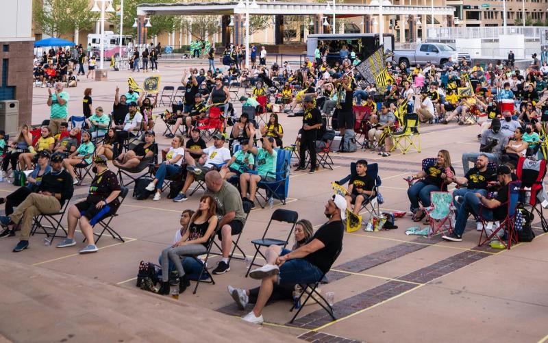 New Mexico United fans sit on Civic Plaza watching a game