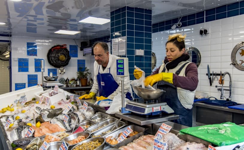 Two staff members working behind the counter at the Fresco Fish Market fishmonger in Kingswood, near Bristol - credit Fresco Fish