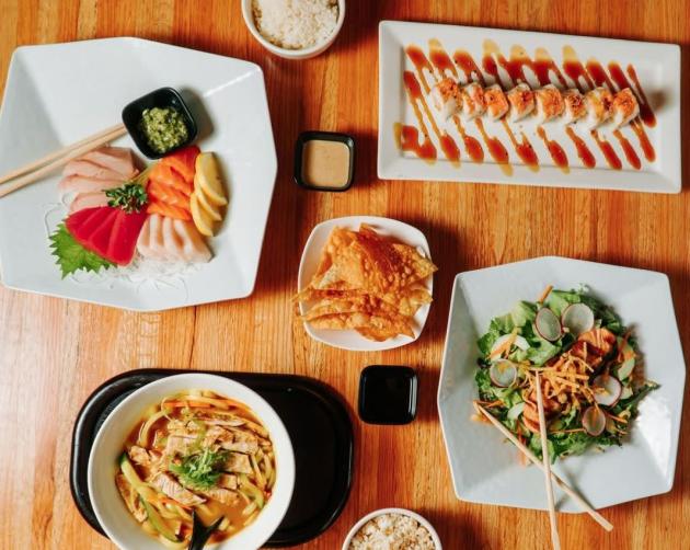 Aerial view of dishes with sushi, chicken salad, wonton chips and soup