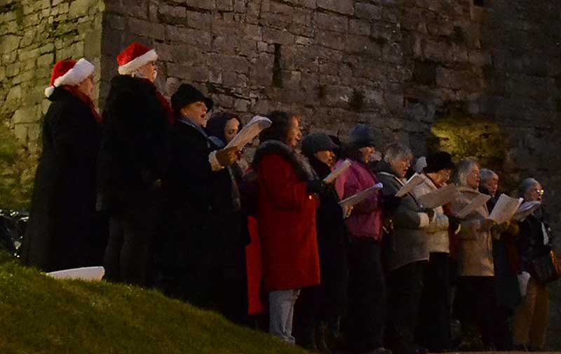 Carol singers in front of Oystermouth Castle