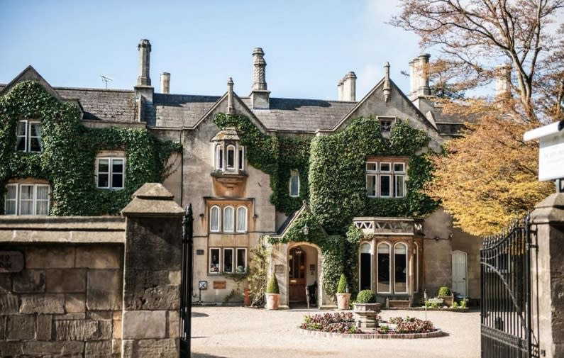 Looking through the open front gates of The Bath Priory at the stunning Georgian manor house covered in ivy