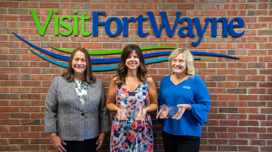 L-R: Jill Boggs, Nicolle Campbell, and Josie O'Donnell pose in front of the Visit Fort Wayne logo sign with the ISAE awards.