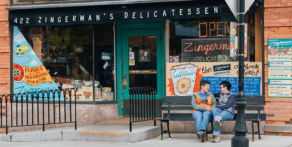Female couple sitting on bench outside Zingerman's deli
