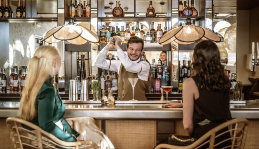 A barman serving two women cocktails at Ricks Bar Bristol