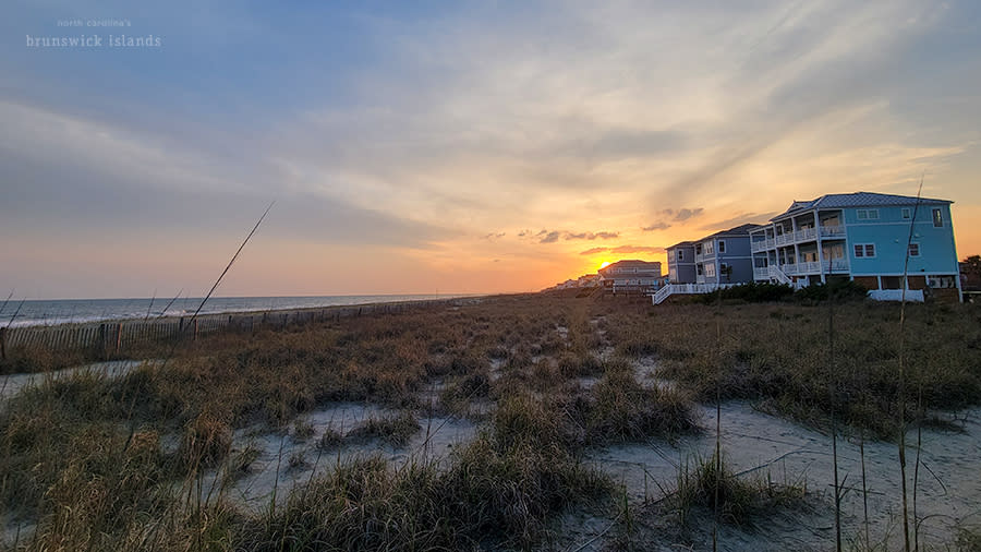 the sun setting over vacation rental homes on Holden Beach