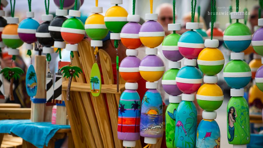 wooden buoys decorated as outdoor decorations for sale at the 2019 NC Festival by the Sea