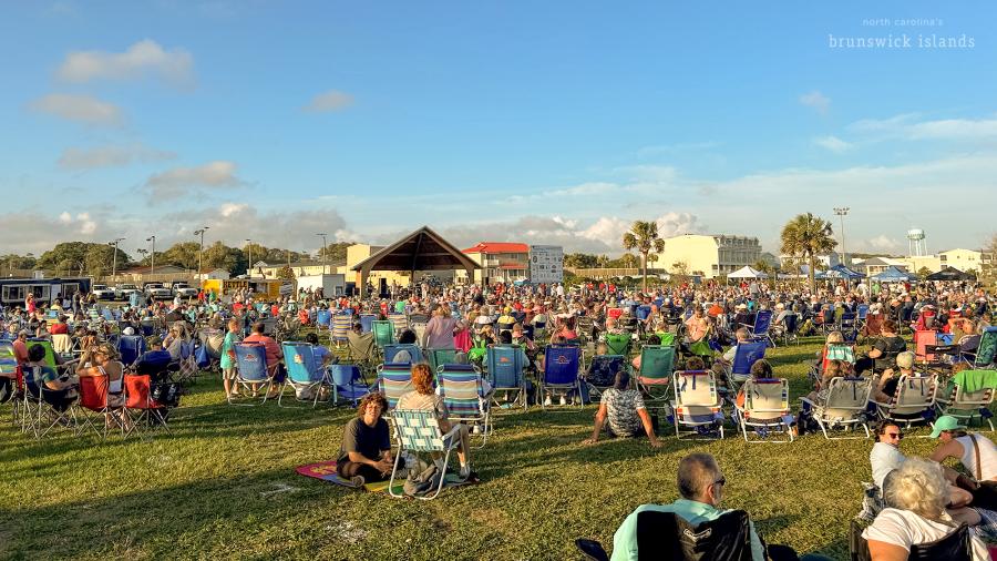 a crowd of people attending an outdoor concert on Oak Island, NC
