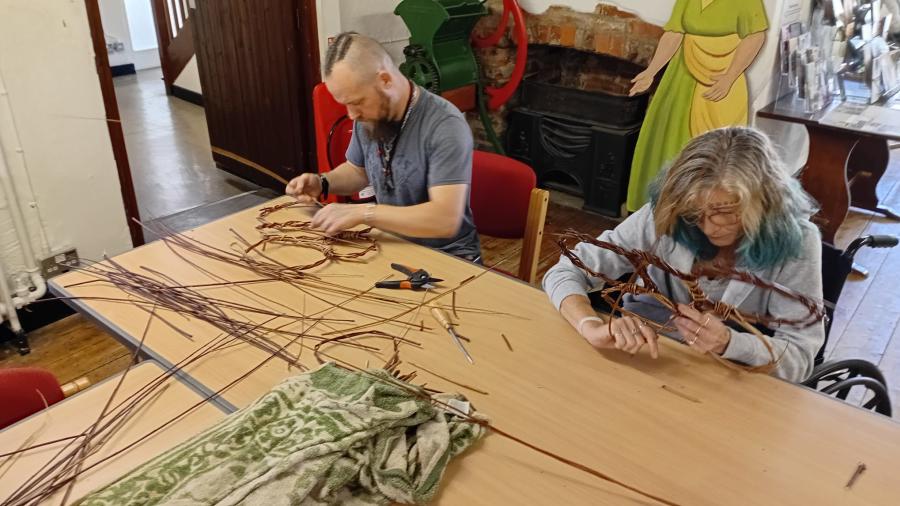 Visitors taking part in a traditional willow weaving workshop at Folk of Gloucester in the Cotswolds.