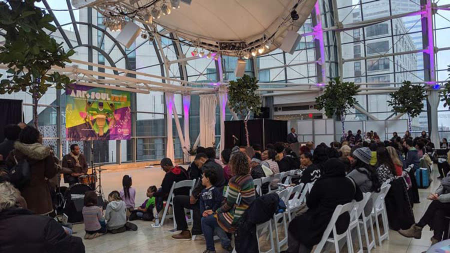 a gathering of people in the Artsgarden, a glass dome room