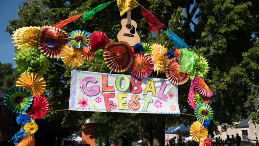 An archway with flowers and a sign saying "Global Fest"