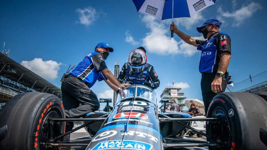 Felix standing next to a blue IndyCar