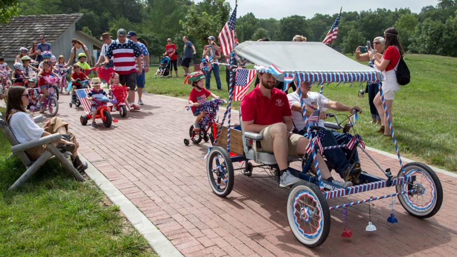 Families take part in the bike parade at Deanna Rose Children's Farmstead held in honor of Independence Day. 