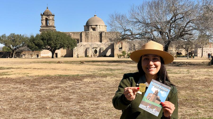 Park Ranger holding Junior Ranger booklet and medal