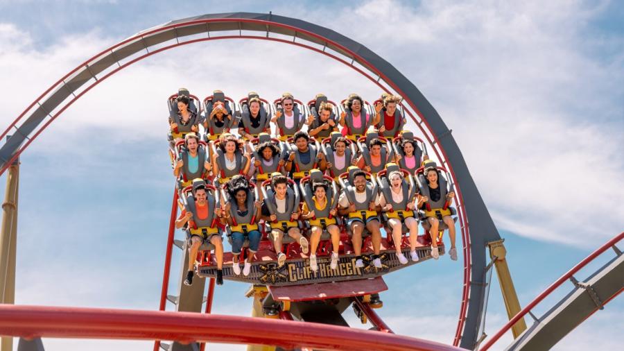 Roller coaster with three rows of people harnessed in