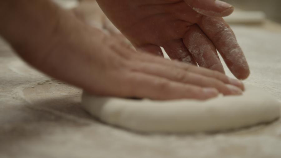 Mozz Artisan Pizza Person rolling out dough