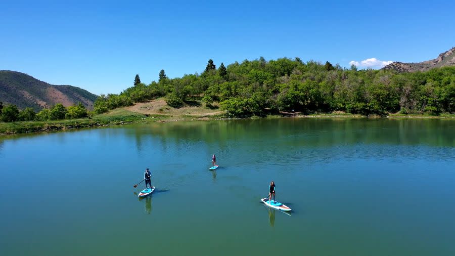 three paddle boarders on maple lake