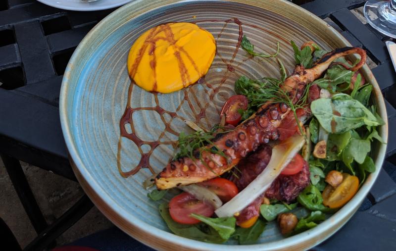 The charred octopus from Molinari's is served with a salad of arugula and cherry tomatoes. 