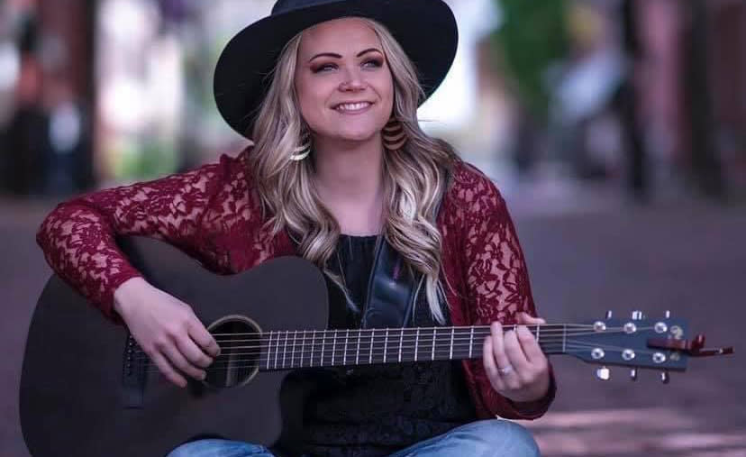 Musician Cynthia Rausch poses with her guitar