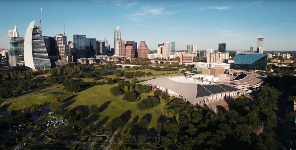 Aerial view of the Palmer Event Center and greenspace with the downtown Austin skyline in the background