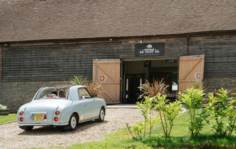 Classic car driving into vineyard doors at Stopham in Sussex