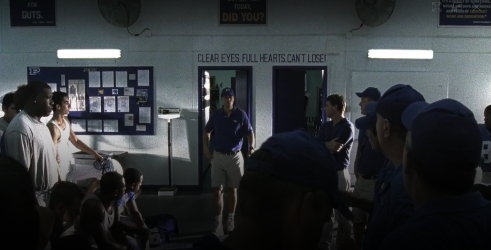 Friday Night Lights Screengrab showing a male coach walking into the Panther Fieldhouse under a sign reading Clear Eyes, Full Hearts Can't Lose