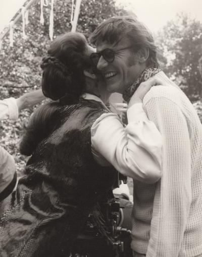 Ava Gardner embracing her friend Roddy McDowall as he smiles.