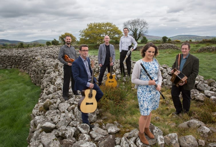 Irish music group Danu standing on rocks with instruments