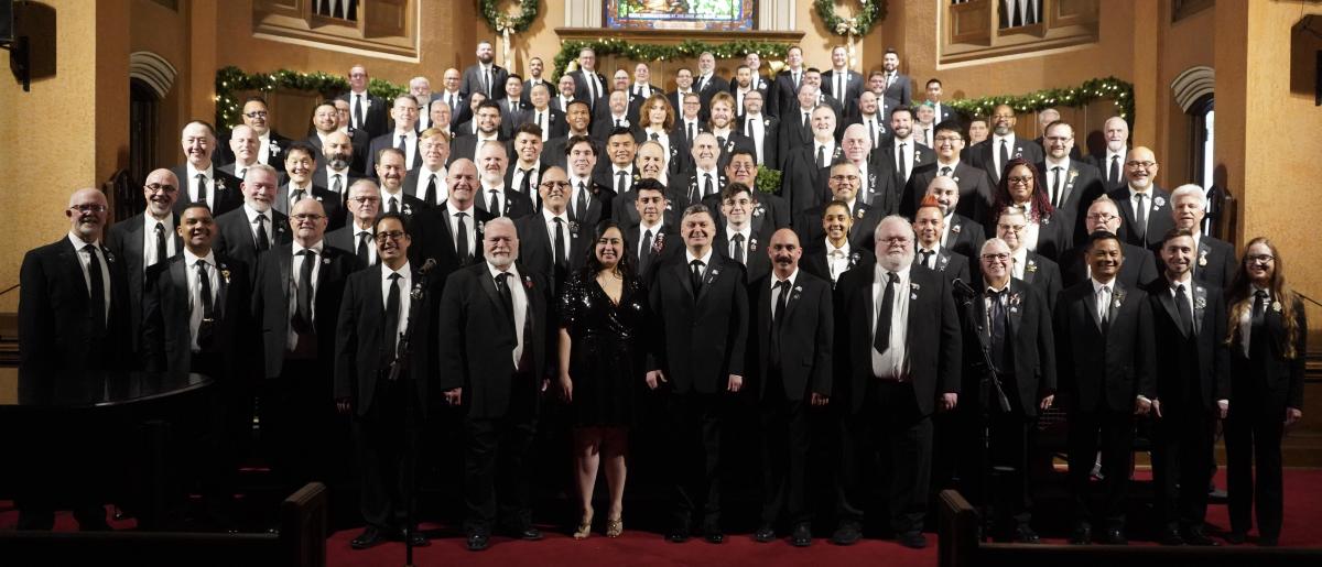 a photo of a large group of singers in black suit and tie