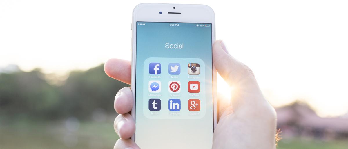 Stock image of an IPhone with social media icons.