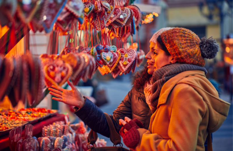 Two women shop for Christmas ornaments at an ourdoor market