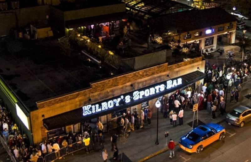 Kilroy's Sports Bar at night with people lined up around the building