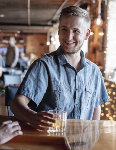 Smiling man holding drink at Waterfront Wine Bar in Manitowoc