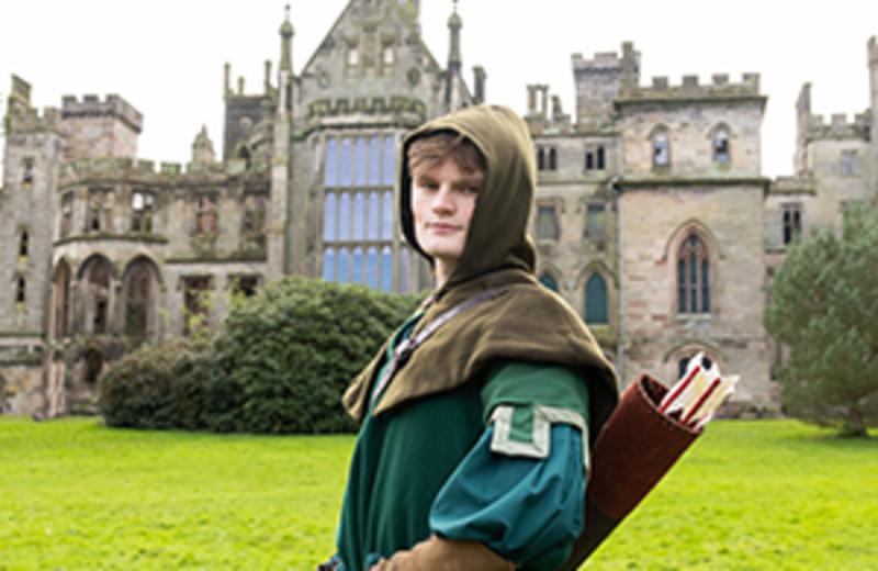 Image shows Robin Hood standing outside the historic manor at Alton Towers Resort, Staffordshire