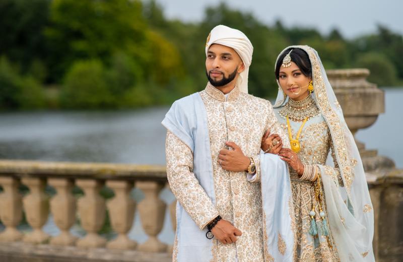 An Asian bride and groom pose for their wedding photo at The Trentham Estate, Staffordshire